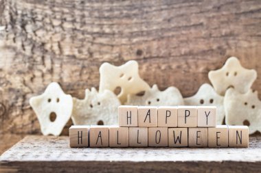 Ahşap küplerde mutlu cadılar bayramı sözleri. Ahşap arka planda bir grup korkunç hayalet, sonbahar modunda cadı şapkasıyla Cadılar Bayramı dehşeti kavramı.