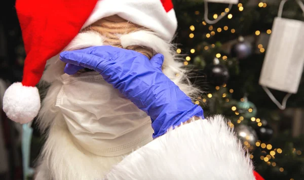 Święty Mikołaj ubrany w maskę twarzy i ochronne rękawice ochronne dla Covid-19, Mikołaja stojącego przy choince niezadowolonego z powodu koronawirusu. — Zdjęcie stockowe