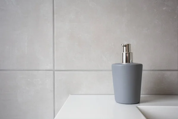 液体石鹸のための灰色の石鹸ディスペンサー、天然石タイル張りのバスルームの背景テクスチャ現代的なデザイン — ストック写真