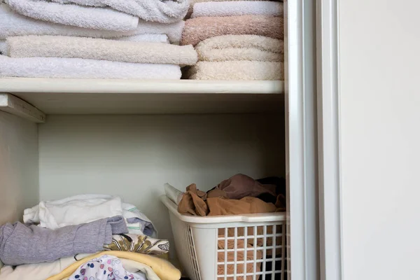 Armoire complète avec vêtements et pile de serviettes en bois blanc placard, l'organisation et le stockage — Photo