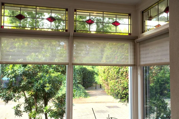 Zbliżenie witraży z czerwonymi i żółtymi sekcjami w przytulnym, pięknym domu z zielonym widokiem — Zdjęcie stockowe