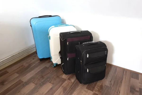 Różne walizki lub torby podróżne w rzędzie w pobliżu białej ściany, nowoczesne torby bagażowe dla turystyki — Zdjęcie stockowe