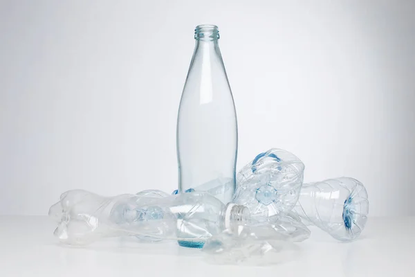Glass bottle vs. plastic bottles, recycling concept