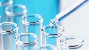 Pipet ile sıvı test tüpleri damla su içinde. Makroyu kapat.