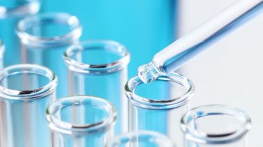 Pipet ile sıvı test tüpleri damla su içinde. Makroyu kapat.