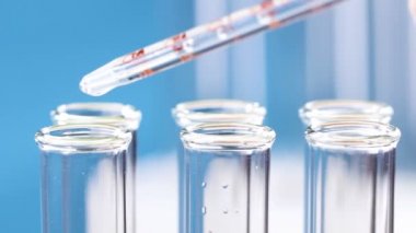 Bir pipet ile ölçülen numaraları damlar test tüpleri içine sıvı. Yakın çekim.