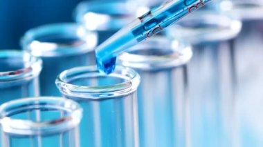 Bir pipet ile ölçülen numaraları damlar test tüpleri içine sıvı. Yakın çekim.