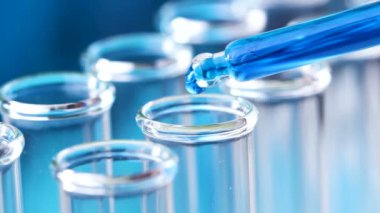 Pipet ile sıvı test tüpleri damla su içinde. Makroyu kapat.
