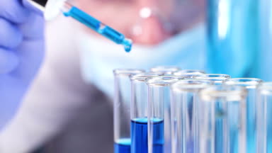 Pipet laboratuvar damla sıvı test tüpü içinde olan bilim adamı. Yakın çekim.