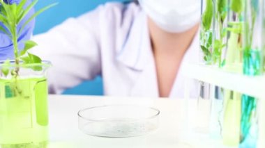 Cımbız ve test tüpleri bitkilerde içinde bir laboratuvarda bilim adamı çalışmaktadır