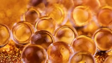 Crystal jel su topları altın doku döndürme parıltı. Makro görüntüleri kapat.