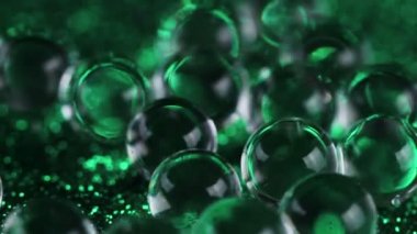 Crystal jel su topları yeşil doku döndürme parıltı. Makro görüntüleri kapat.
