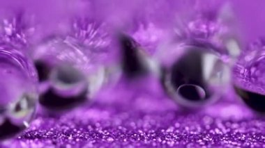 Crystal jel su topları üzerinde mor glitter doku döndürme. Makro görüntüleri kapat.