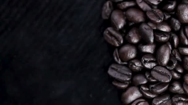 Granos Café Negro Girando Sobre Superficie Negra Primer Plano Las — Vídeos de Stock