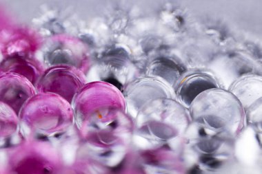 Pembe ve gümüş yüzeyde dönen hidrojel top. Makroyu kapat.