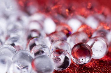 Hidrojel top kırmızı ve gümüş yüzeyde döner. Makroyu kapat.