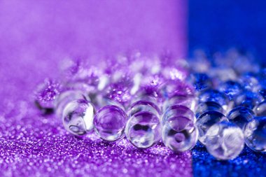 Hidrojel topu mavi ve mor yüzey üzerinde döner. Makroyu kapat.