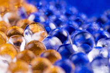 -Mavi ve Altın yüzeyinde dönen hidrojel top. Makroyu kapat.