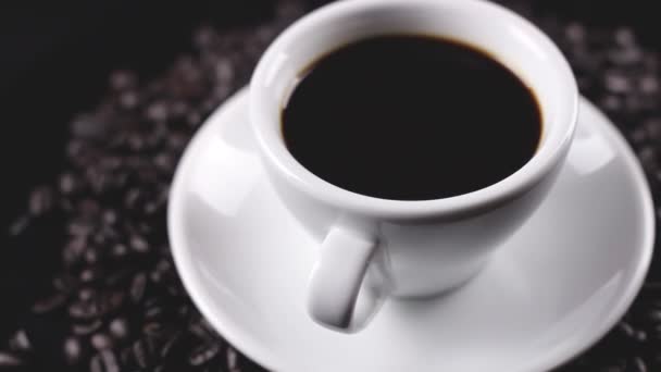 Черный Кофе Белой Чашке Тарелке Кофейными Зернами Вращается Темной Поверхности — стоковое видео