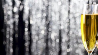 İki şampanya bardağı tatil tinsel bokeh yanıp sönen arka plan üzerinde yakın çekim.