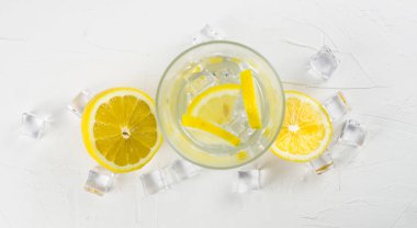 Cam ve buz küpleri ile taze dilimlenmiş limon. Clos kadar.