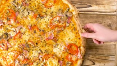 El bir parça ahşap yüzey lezzetli pizza alır. 4 k kapatın.