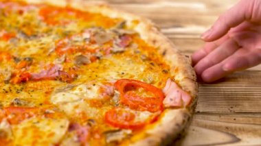 El bir parça ahşap yüzey lezzetli pizza alır. 4 k kapatın.