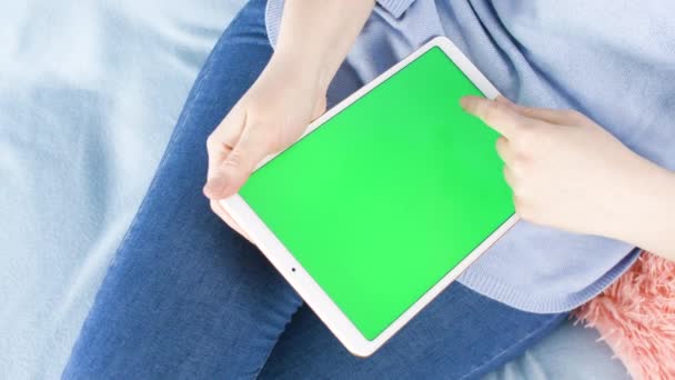 Jonge Vrouw Zetel Bank Een Witte Tablet Met Groen Scherm — Stockvideo