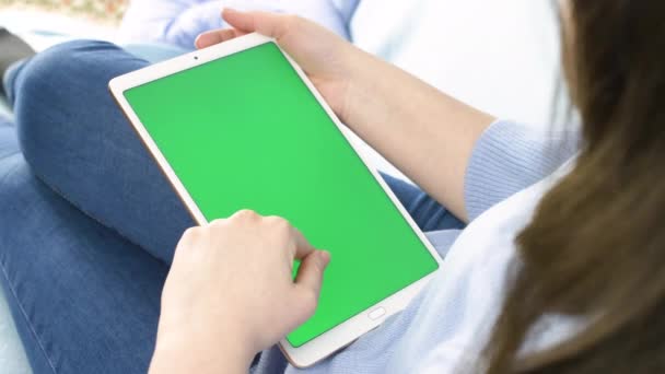 Jonge Vrouw Zetel Bank Een Witte Tablet Met Groen Scherm — Stockvideo