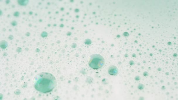 薄緑色のパステルウォーターで石鹸泡をクローズアップ 4Kマクロフッテージ — ストック動画