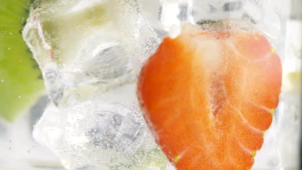 Primer Plano Fruta Fresca Rodajas Giratorias Vaso Con Agua Cubitos — Vídeos de Stock