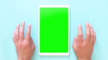 Erkeklerin elleri bir tabletle yüzeye vuruyor. Yeşil ekran görüntüleri. 4k üst görünüm.