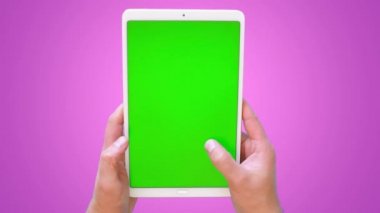 Erkeklerin elleri bir tabletle yüzeyde kaydırır. Yeşil ekran görüntüleri. 4k. Üst görünüm.