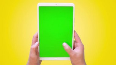 Erkeklerin elleri bir tabletle yüzeyde kaydırır. Yeşil ekran görüntüleri. 4k. Üst görünüm.