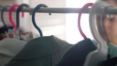 Farklı bez ile gardırop kadın elini yakın. 4k yaşam tarzı görüntüleri.