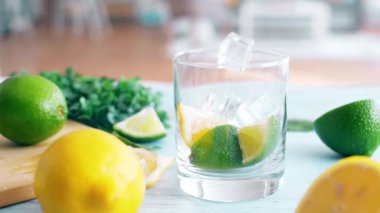 Dilim kireç ve limon ile buz düşen giriş cam yavaş hareket kapatın. Taze coctail doğrama tahtasıüzerinde kalmak. Yaz içkisi.