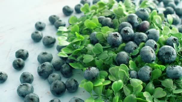 Close Fresh Sweet Blueberry Green Leaves Rotating Blue Wood Surface — Stock Video