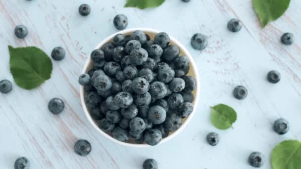 Nice Yummy Fresh Blueberry White Plate Rotating Blue Wood Surface — Stock Video