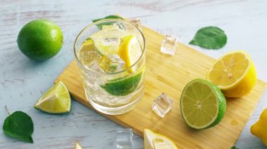 Ahşap mutfak masasında narenciye ile taze kokteyl kapatın. Yakından kapatın. Yaz içkisi. 4k.