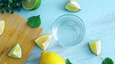 Cam ile ahşap mutfak yüzeyinde dilimlenmiş kireç ve limon. 4k görüntüleri kapatın.