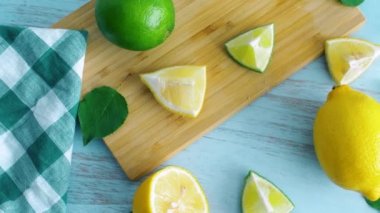 Ahşap mutfak yüzeyinde dilimlenmiş limon ve kireç. Narenciye taze meyve. 4k görüntüleri kapatın.