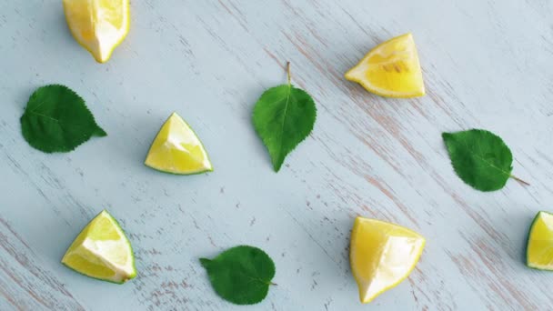 青い木のテクスチャ表面に緑の葉と新鮮なスライスライムとレモンのクローズアップ キッチンに4K柑橘系の果物 — ストック動画