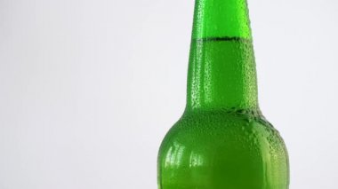 Taze bir şişe beyaz arka plan üzerinde dönen su damlaları ile bira olabilir. 4k yavaş çekim görüntüleri.