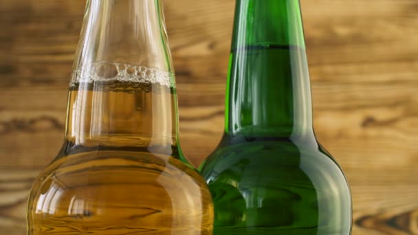 Twee Bierflesjes Draaiend Hout Textuur Oppervlak Close Van Alcohol Drinken — Stockvideo