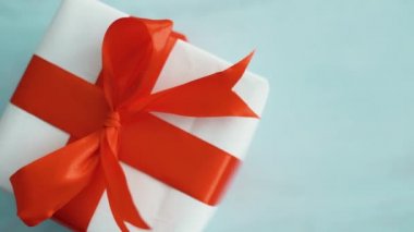 Kırmızı ipek kurdele dönen beyaz hediye kutusu. Noel, kara cuma ve diğer tatiller için hediye kutusu. 4k görüntüleri kapatın.