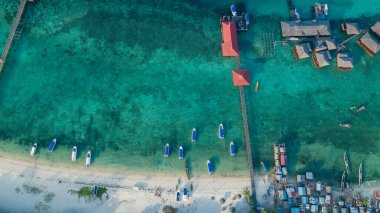 Sakin bir günde denizde birkaç evle berrak sulara demirlediler. Bu fotoğraf Malezya 'daki Mabul Adası' nda, dalmak ve tatilin tadını çıkarmak için mükemmel bir yer.