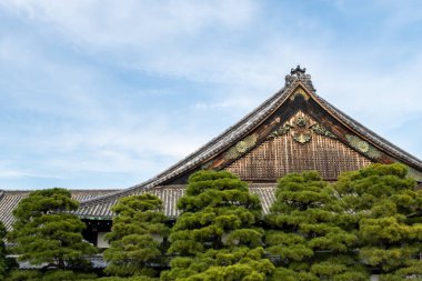 Kyoto 'daki Nijo Kalesi' nin çatısını altın madalyalar ve detaylı sanat eserleri ile ahşap oymuş, Kyoto, Japonya. Mavi gökyüzü arkaplanı.