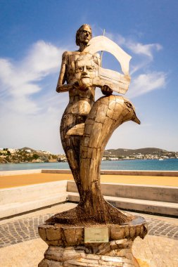 FINIKAS, Siros Adası, Yunanistan. Finikas Marina 'da bir insan ve yunus heykeli.