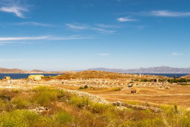 Yunanistan 'daki Delos Adası manzarası - kristal mavi gökyüzü ve antik harabelerin büyük alanı ile adadaki tepenin manzarası.