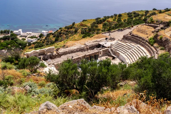 MILOS, Yunanistan. Milos Adası, Cyclades, Yunanistan 'daki Trypiti Kasabası yakınlarında Akdeniz' in arka planında yer aldığı yeşil bir tepenin üzerindeki Milos Antik Tiyatrosu kalıntıları.